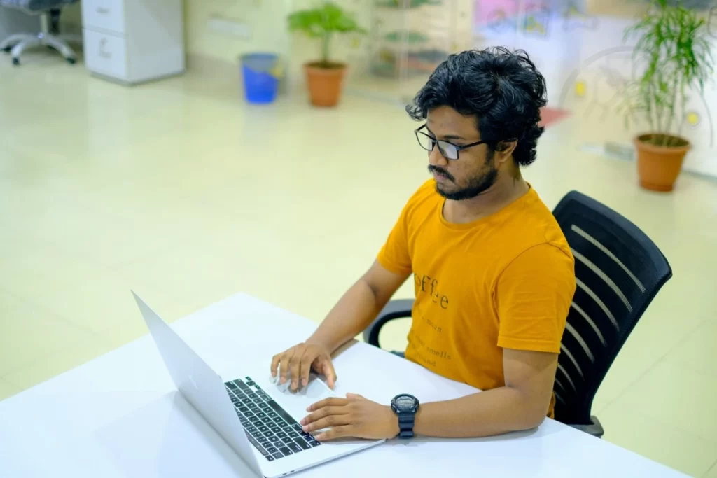 Jovem profissional trabalhando em um notebook em ambiente de escritório sobre Código de tributação municipal para nota fiscal de serviços jurídicos