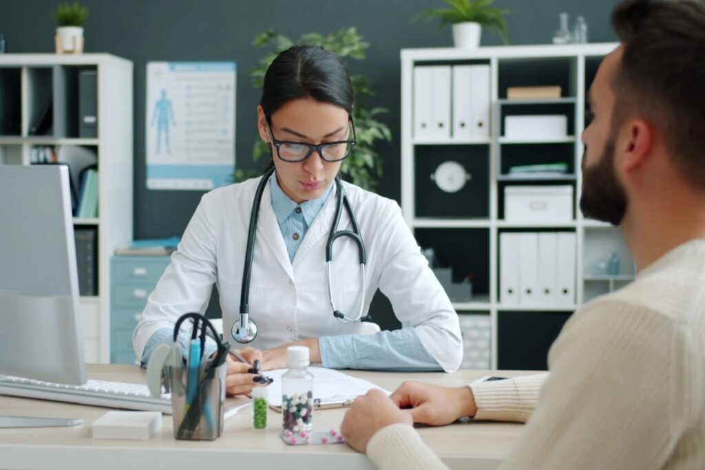 Medica sentada em seu consultorio prescrevendo uma receita para o parciente, representando: Rateio de consultório: como emitir nota fiscal quando médicos dividem sala e despesas